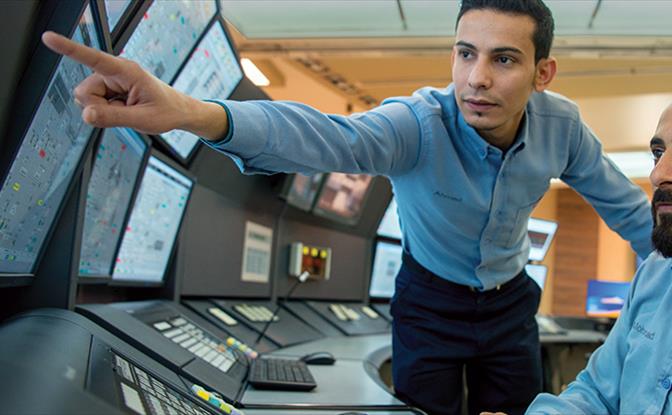 Two men looking at multiple monitors