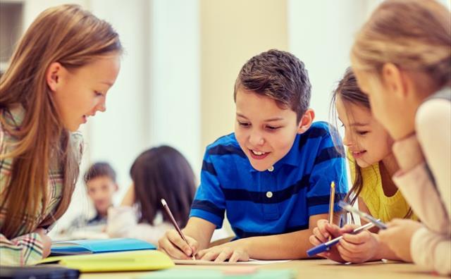 Group of kids working together on school