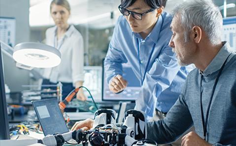 Two engineers working with robot