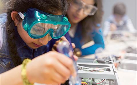 Science and tech education - a girl assembling electronics