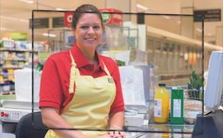 Cashier behind protective screen