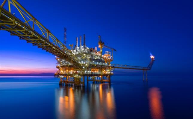 Offshore oil and gas central processing platform in sunset