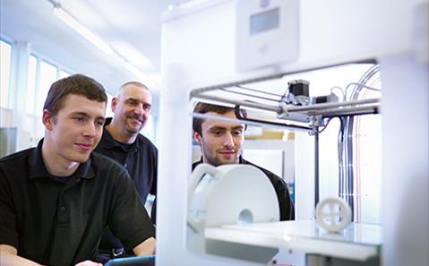 Instructor with apprentices and 3D printing machine