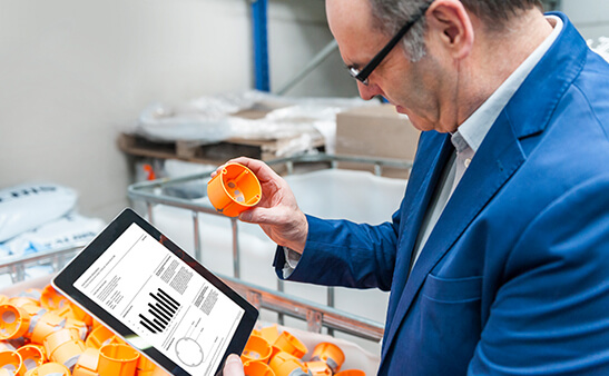 A man holding looking at a tablet screen with a chart